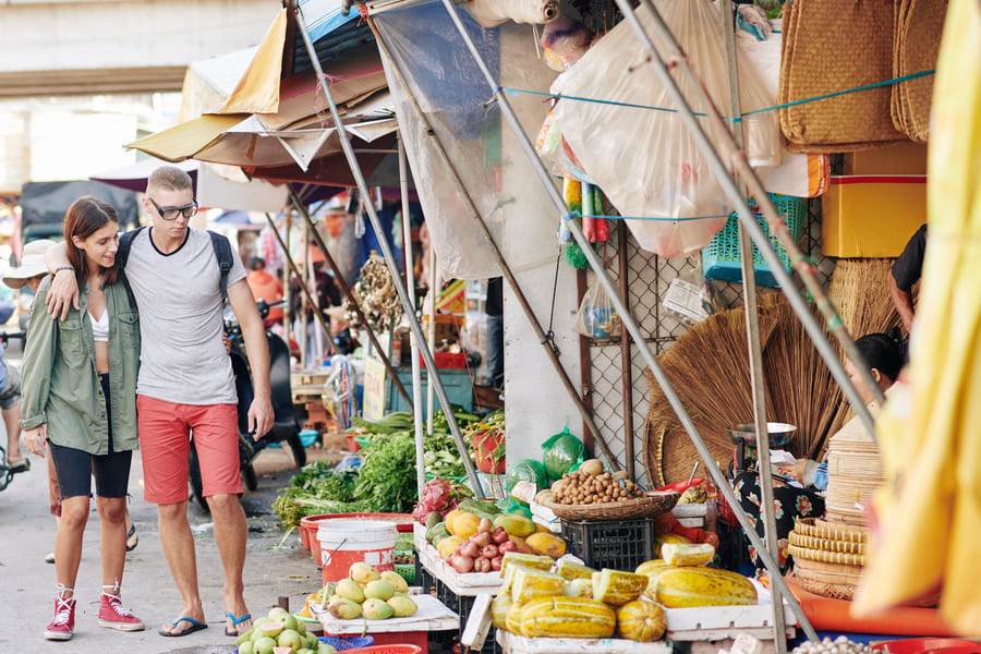 Foto de mujer y hombre viajeros en mercado tradicional en China