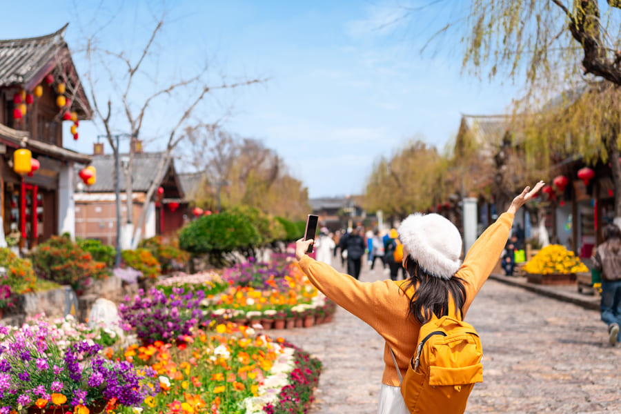Mujer viajera en Yunnan en China, con jardines de fondo